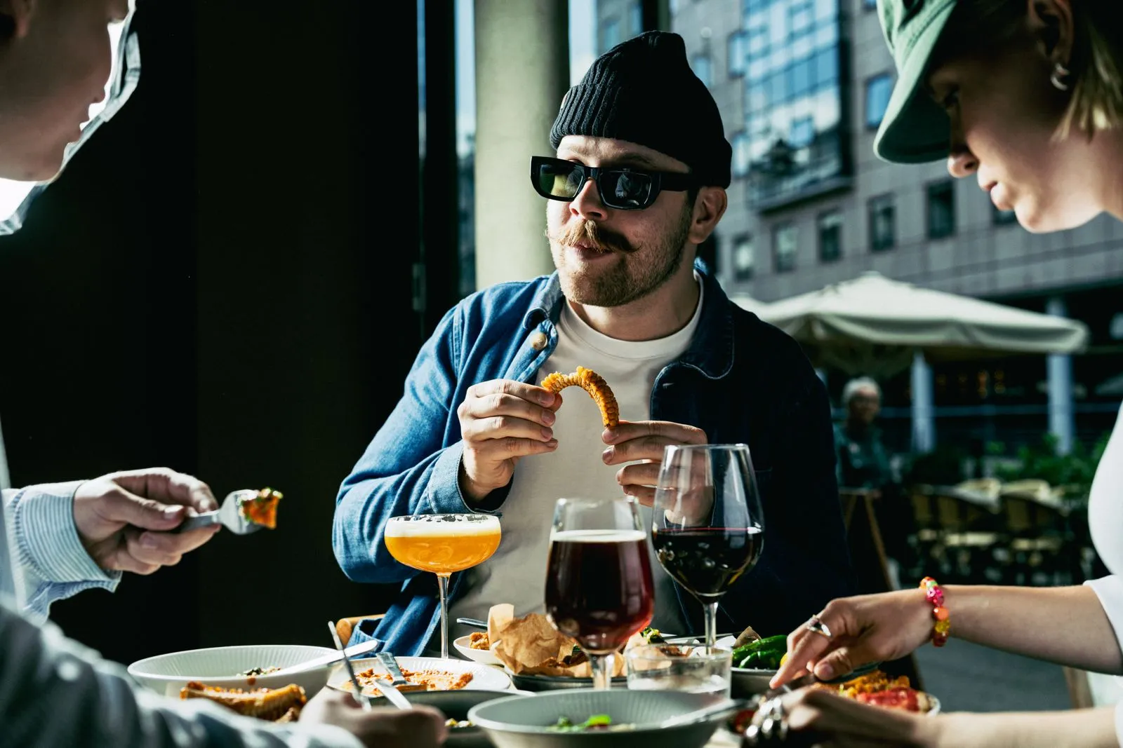 Venner deler mad og drinks ved et bord på Å46
